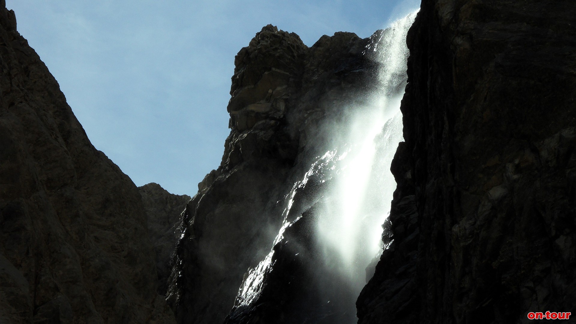 Oberhalb einer Bachquerung zischt ein Wasserfall in die Tiefe.